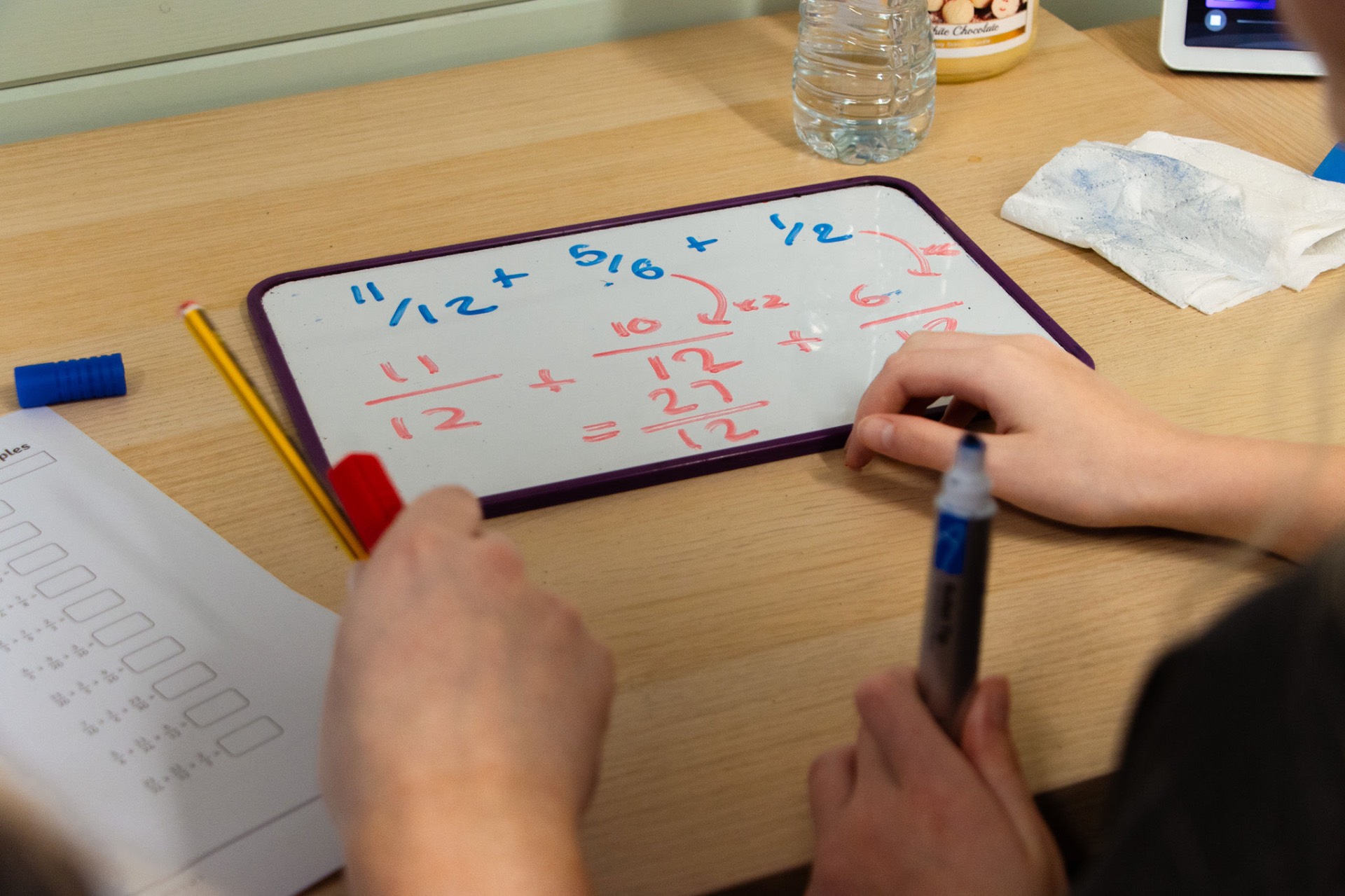 Fractions written on a tutoring whiteboard