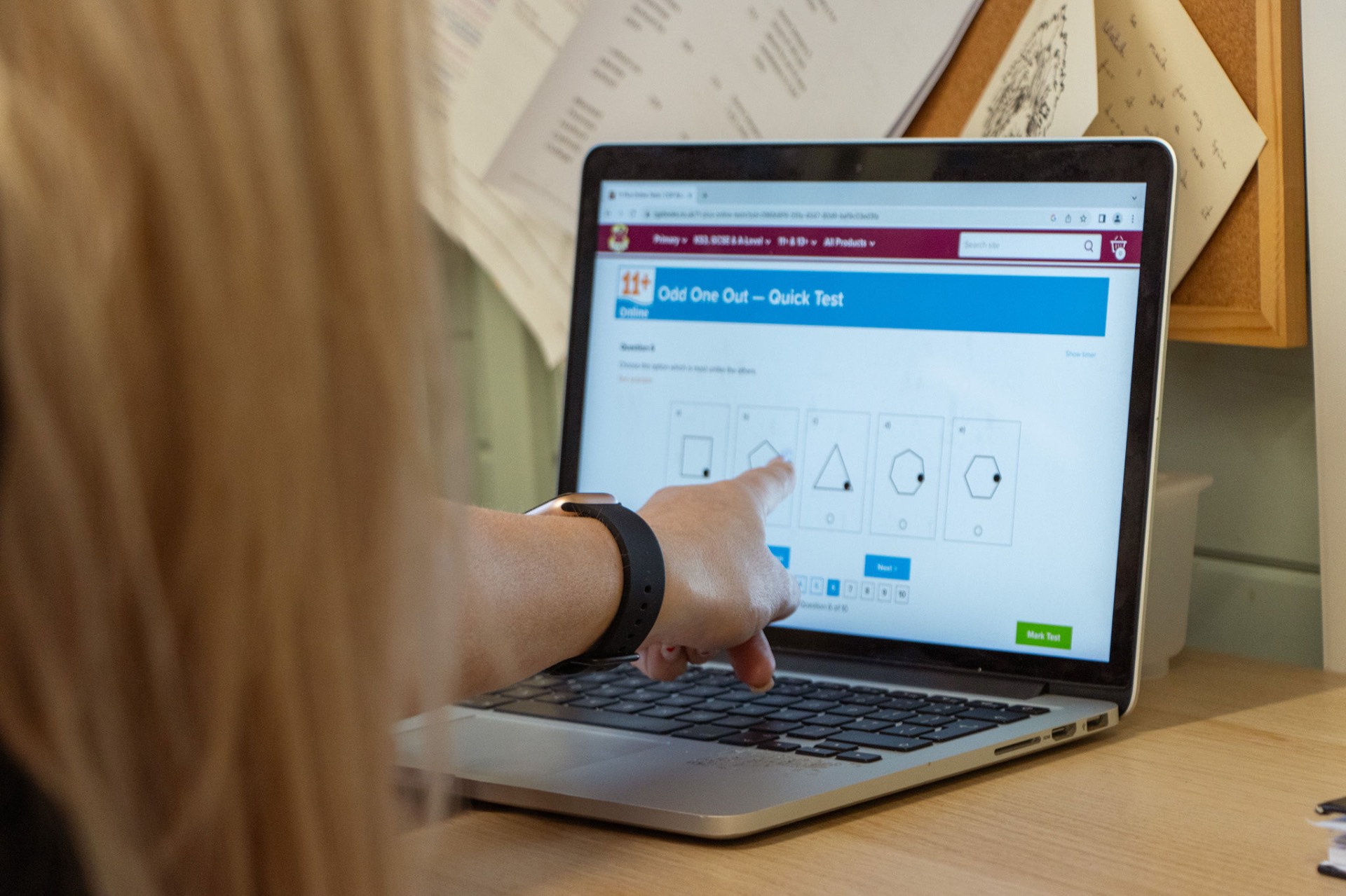 A tutor and student working through 11+ practice on a laptop